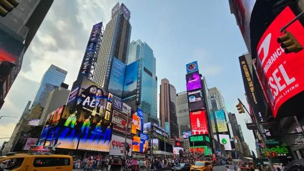 The bright billboards and crowds of Times Square at dusk, a vibrant free sight in NYC