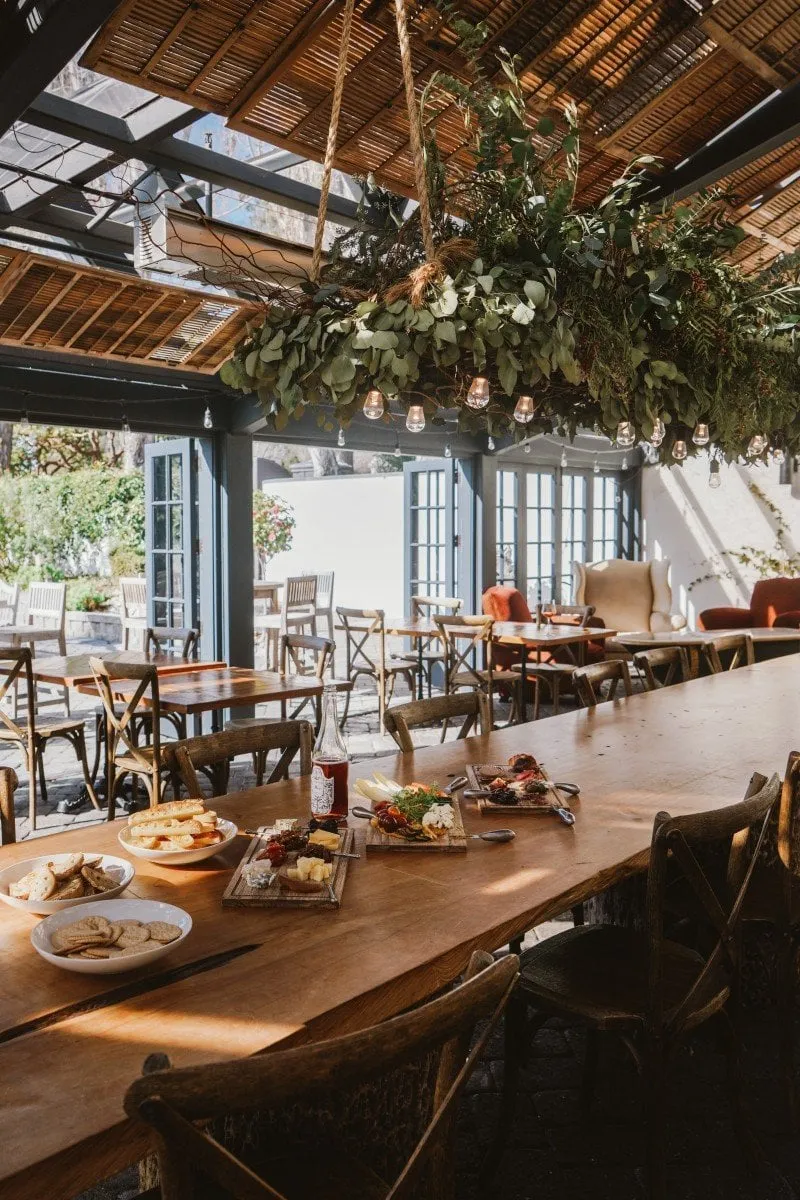 The exterior of Folktale Winery restaurant in Carmel Valley, showing outdoor seating and vineyard views.