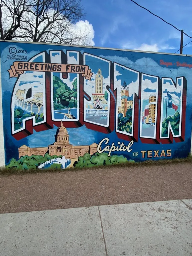 The iconic 'Greetings from Austin' mural, a popular spot for solo travelers to take photos.