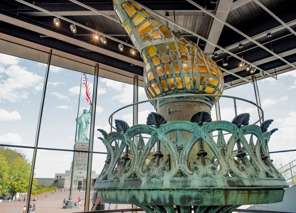 The original and damaged torch of the Statue of Liberty displayed inside the museum, a key artifact during your freiheitsstatue besichtigen
