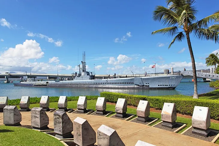 The solemn USS Arizona Memorial floats above the sunken battleship at Pearl Harbor.