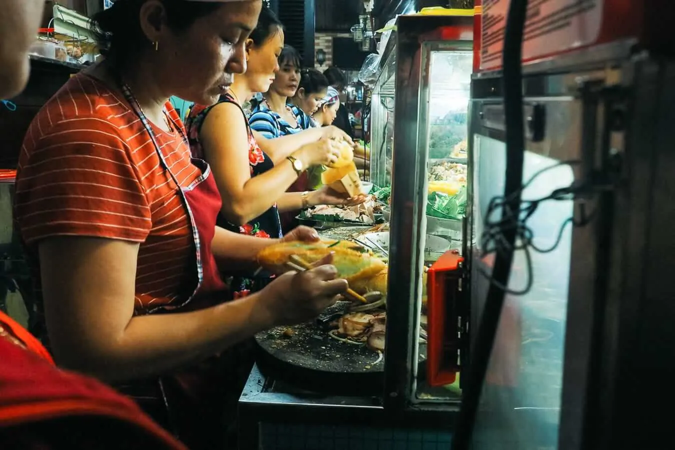The team at Bahn Mi Phuong create Vietnamese sandwiches for the long line of customers. Photo: Agnuush Monstar