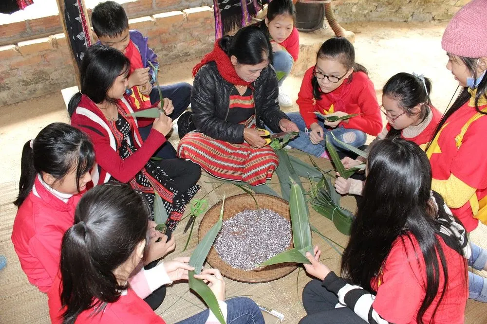 Tourists learning to prepare traditional dishes at a demonstration within the National Village for Ethnic Culture and Tourism