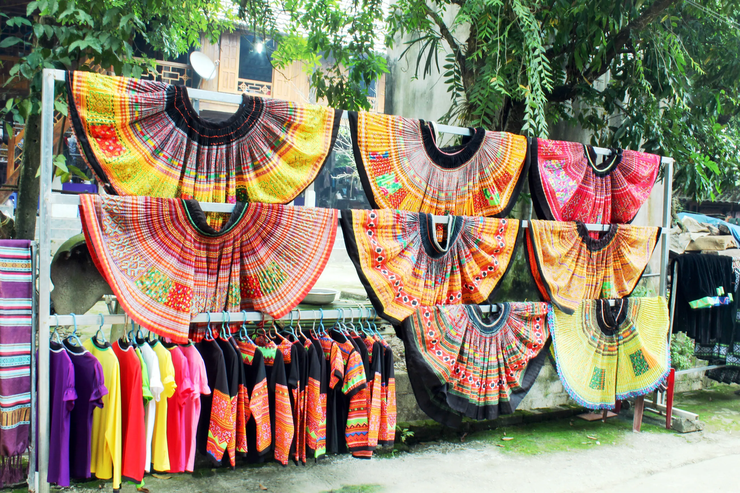 Traditional ethnic clothing displayed for sale, including colorful fabrics and headpieces