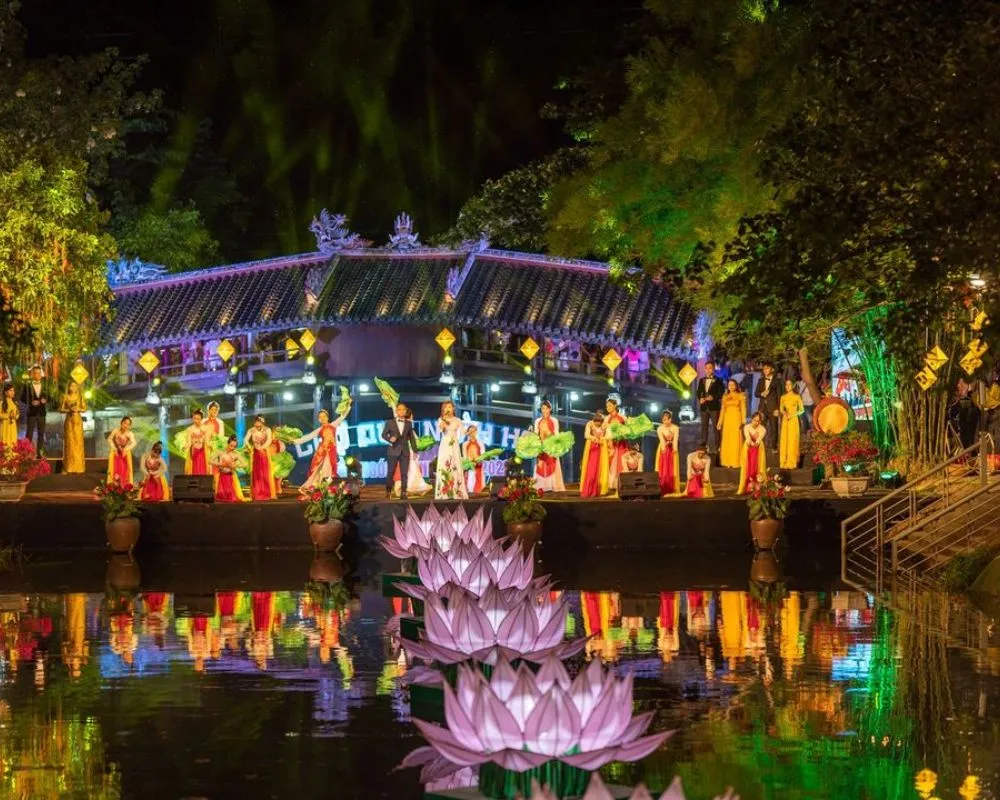 Traditional music and dance performance near Thanh Toan Tile-roofed Bridge, highlighting folk culture at the Hue Festival