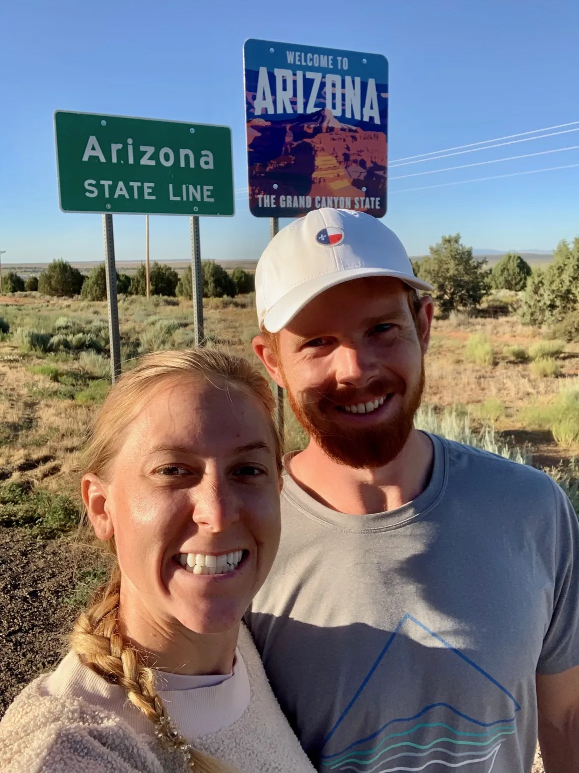 Traveler standing at a state line sign, a common sight on an adventurous trip Texas and beyond