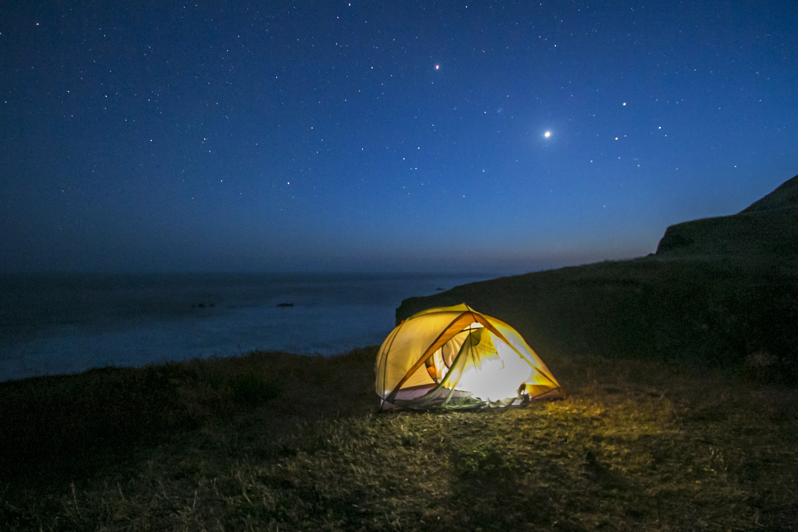 Two backpackers walking along a rugged beach on the Lost Coast