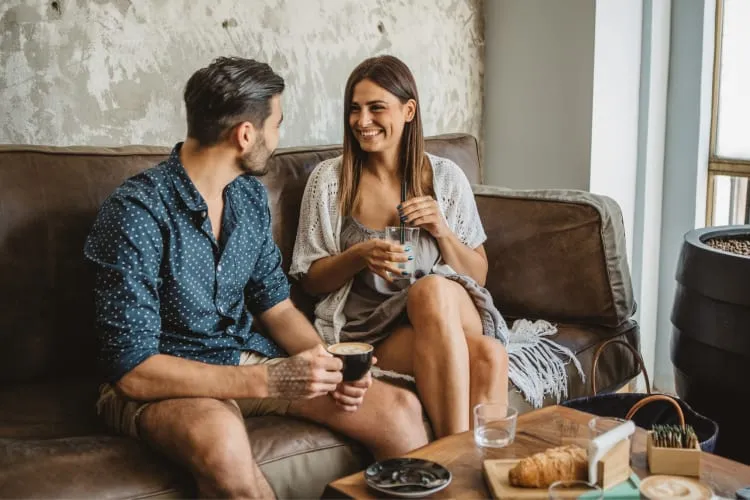 Two people on a couch having coffee and chatting, a simple yet charming date idea in Las Vegas cafes