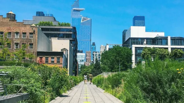 Two people walk along The High Line urban park on a sunny day in NYC