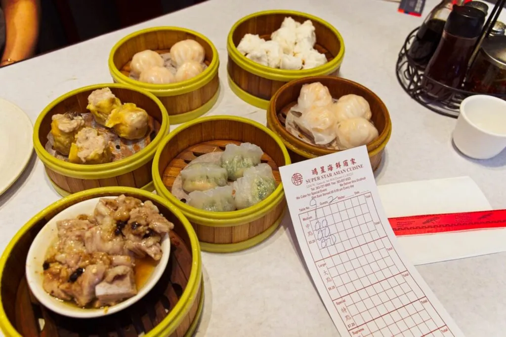 Variety of fresh dim sum dishes with a price card at Super Star Asian Cuisine, offering authentic brunch in Denver.