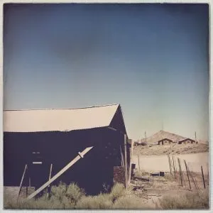 Vast Nevada landscape with a barn, seen during the girl from road trip journey