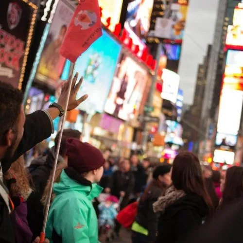 View of Times Square and Broadway theaters at night, bustling with activity