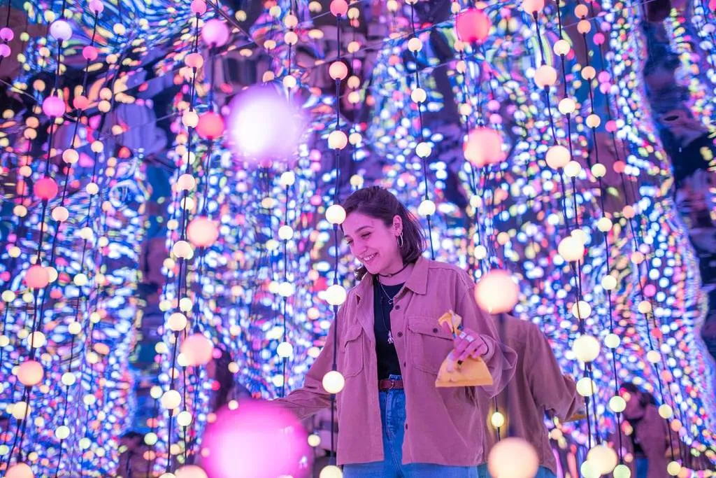 visitor standing among infinity lights at Dopamine Land, an example of a unique immersive experience when deciding where to go in NYC today.