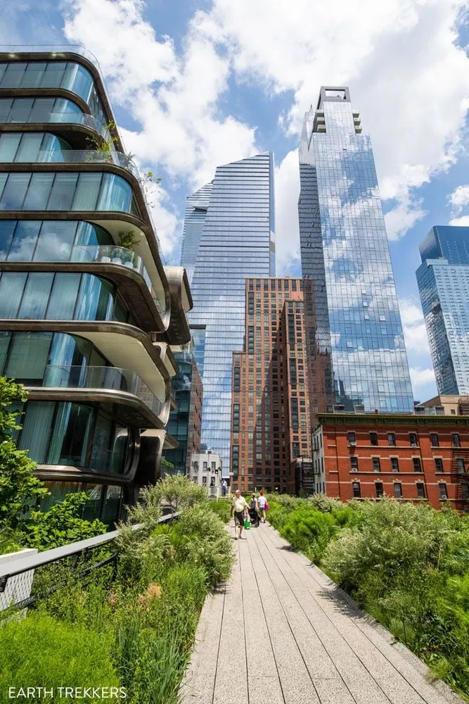 Walkway along the High Line elevated park with city buildings