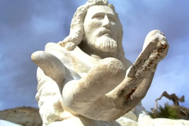 White concrete sculpture depicting a religious scene in a desert park
