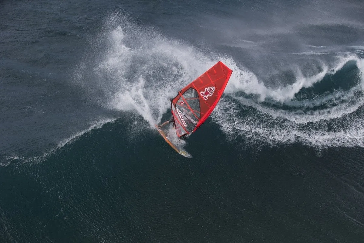 Windsurfers riding large waves off the coast of Ho'okipa Beach in Maui.