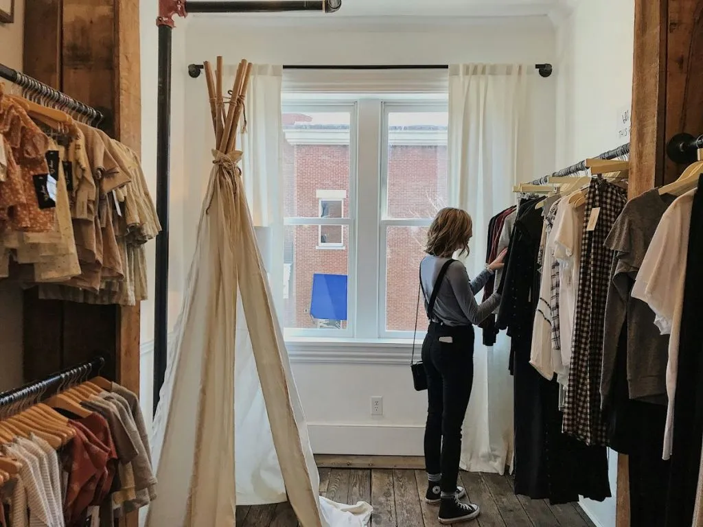 Woman browsing clothing in an upscale boutique on the Upper East Side NYC
