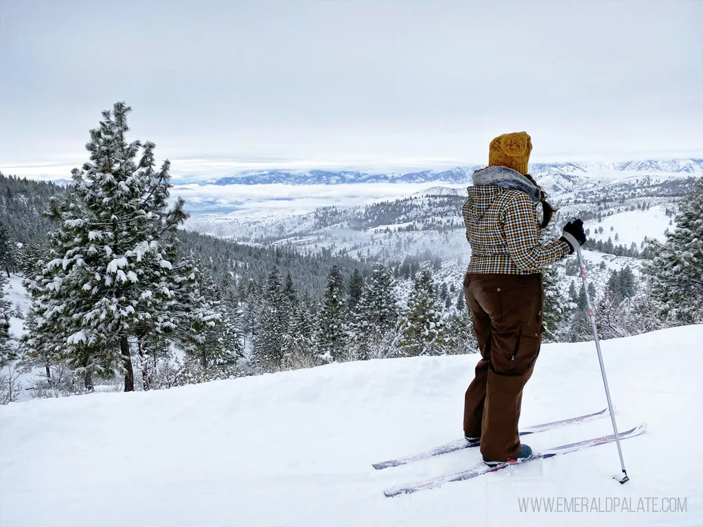Woman cross-country skiing on a snowy ridge overlooking Lake Chelan