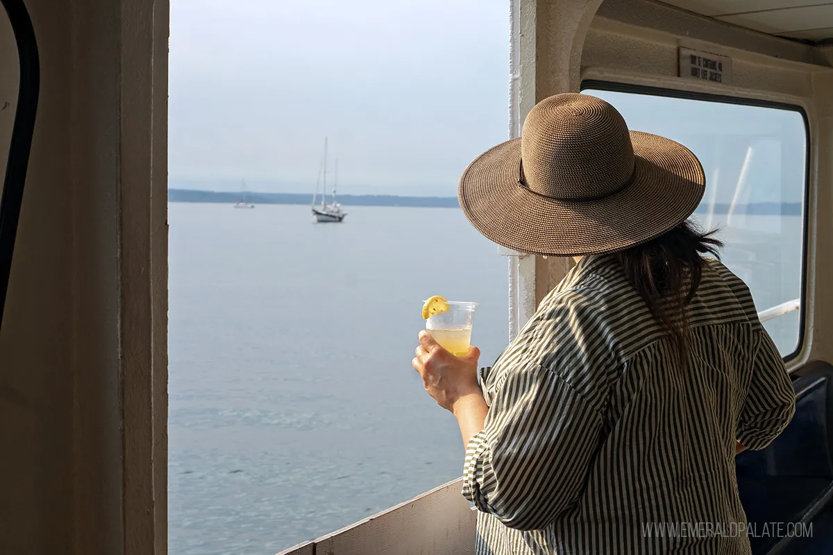 Woman enjoying a drink with views on an Argosy Cruise in Seattle