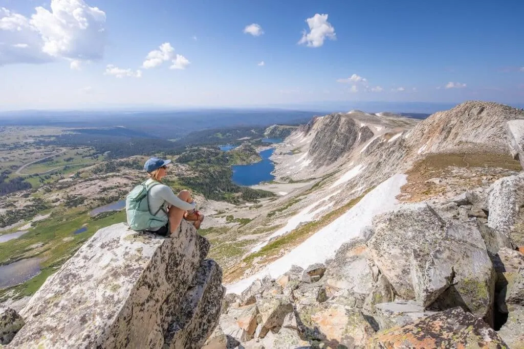 Woman on a rock overlooking Medicine Bow Peak and lakes in Medicine Bow-Routt National Forests - Scenic Things To See And Do In Wyoming