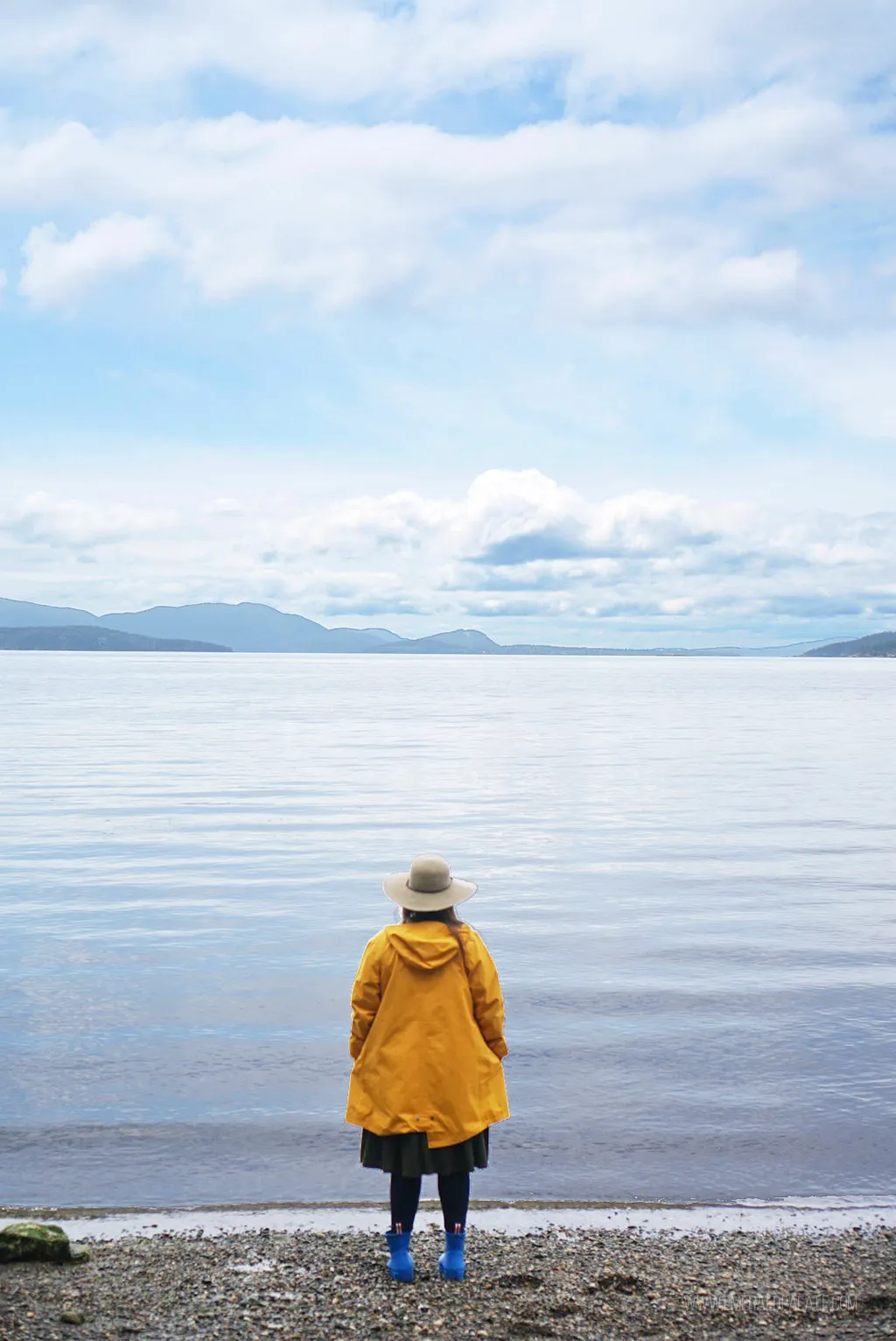 Woman overlooking the water from a beach area in a park with island views