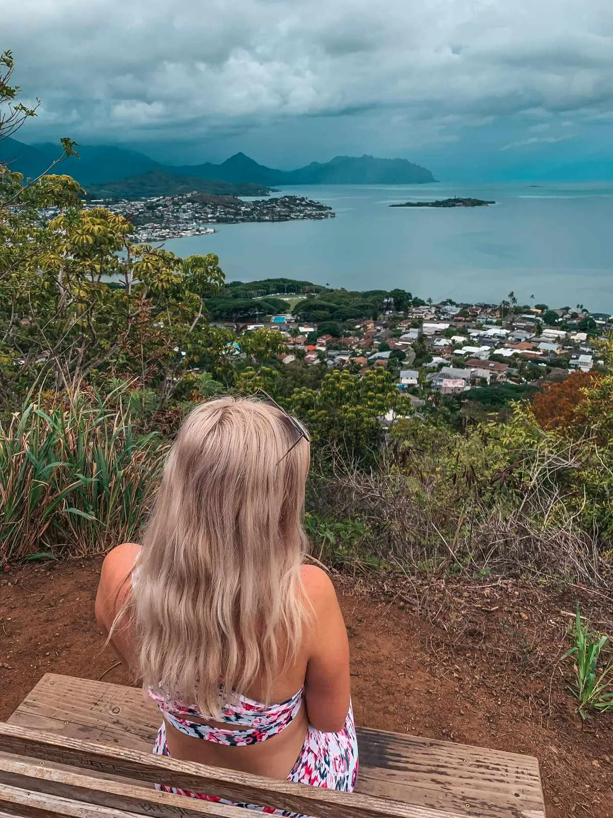 Woman sitting on a bench overlooking the view on the Friendship Gardens Trail, Kaneohe