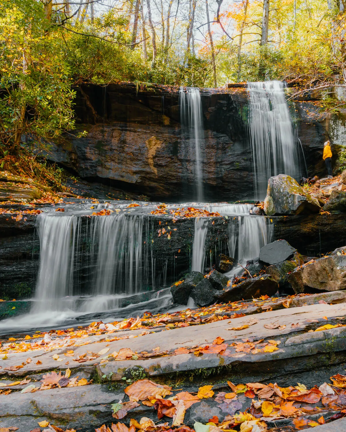 Woman standing in front of Grassy Creek Falls in Little Switzerland, NC