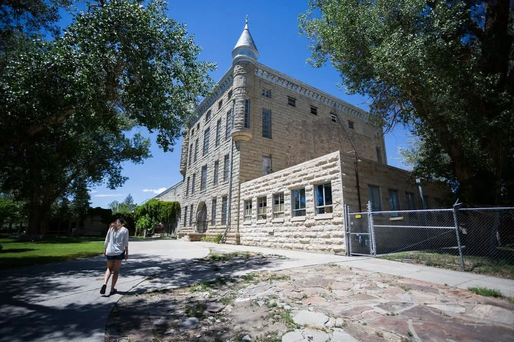 Woman walking up to the historic Wyoming Frontier Prison in Rawlins - Historical Things To See And Do In Wyoming