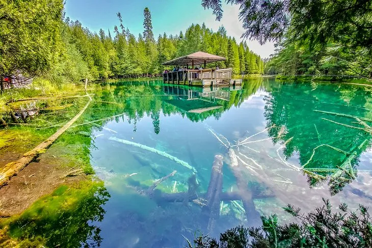 Wooden observation raft over the clear blue-green waters of the Kitch-iti-Kipi spring
